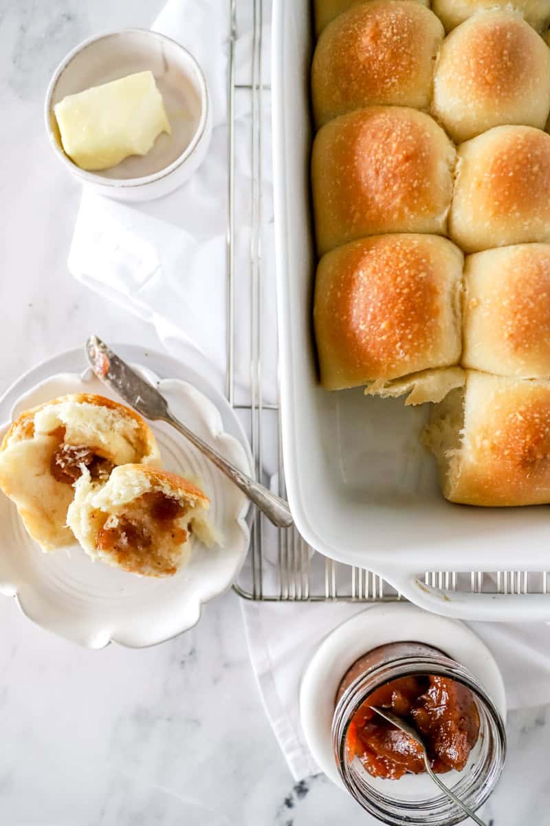 A top view of sourdough dinner rolls with butter and jelly.