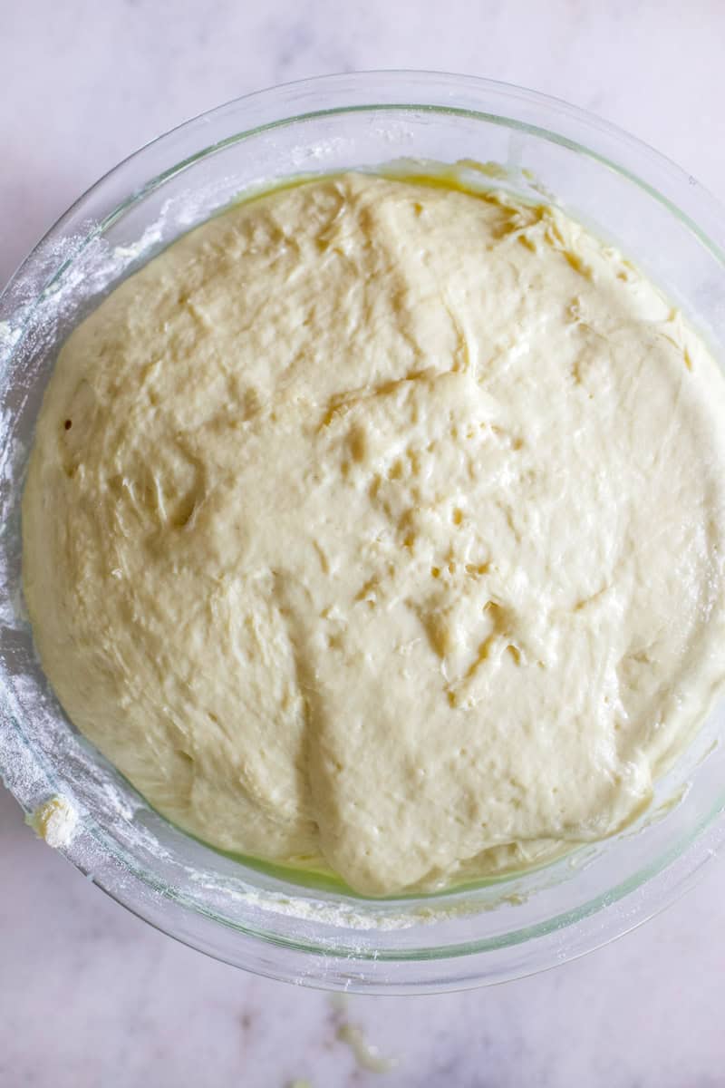 Step 3 of making sourdough cinnamon rolls is bulk fermentation, letting the dough rise in an airtight container.
