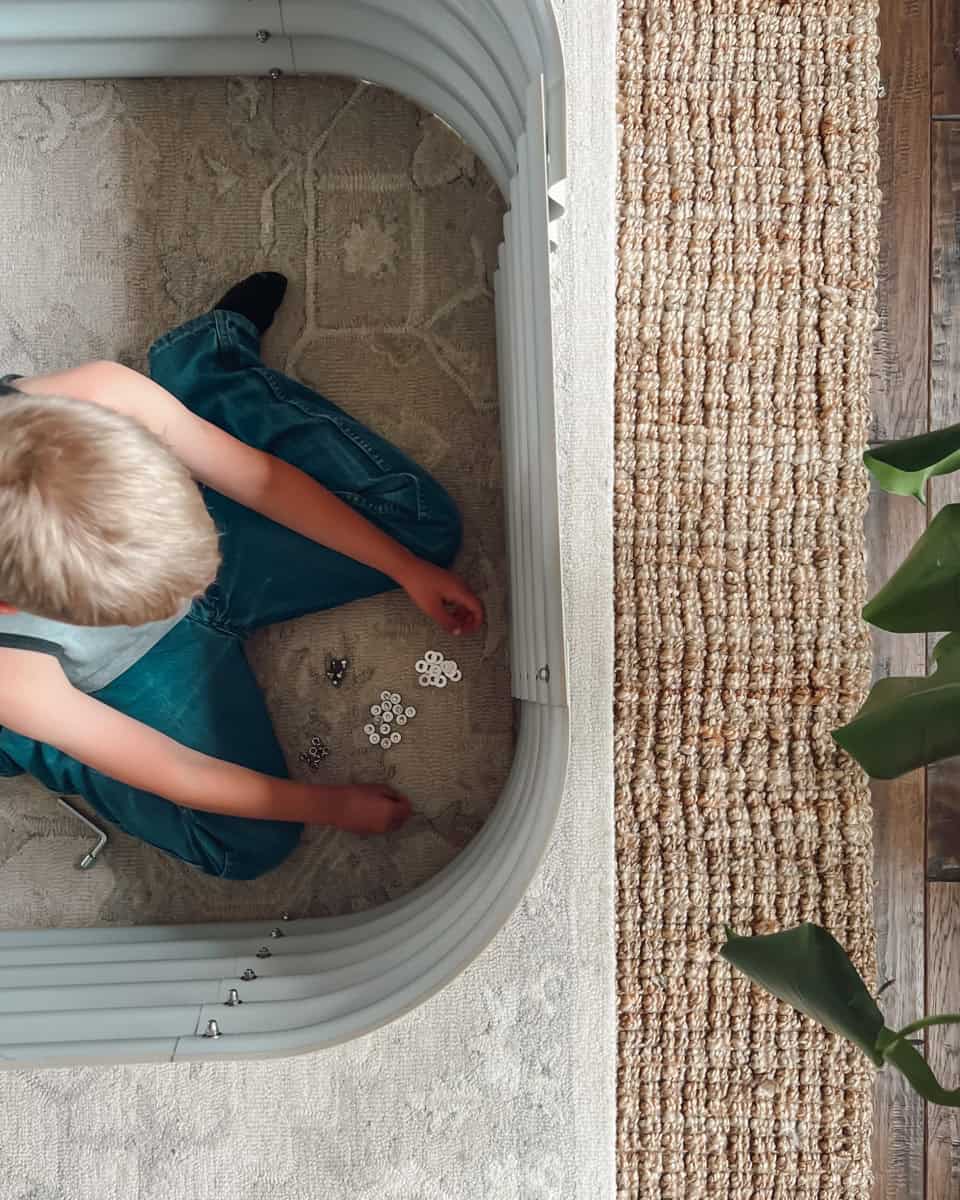 A child assembling a vego garden raised bed.