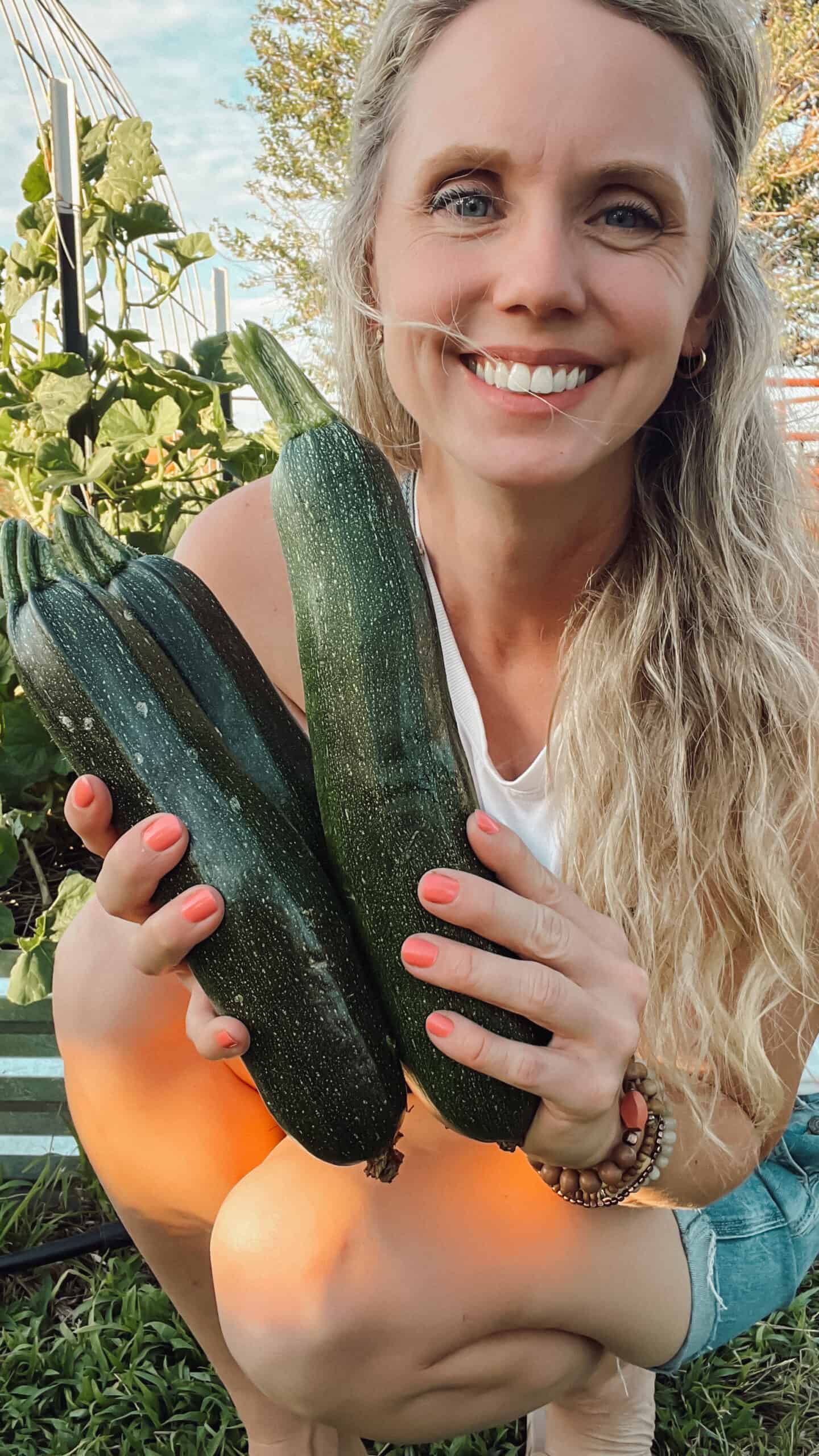 Meg from Ninnescah Homestead holding fresh picked zucchini.