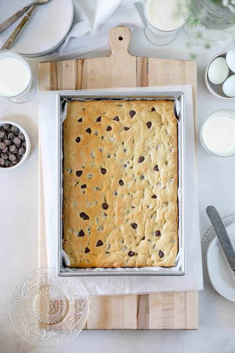 Fresh baked sourdough blondies in a metal pan, ready to be sliced, top view.