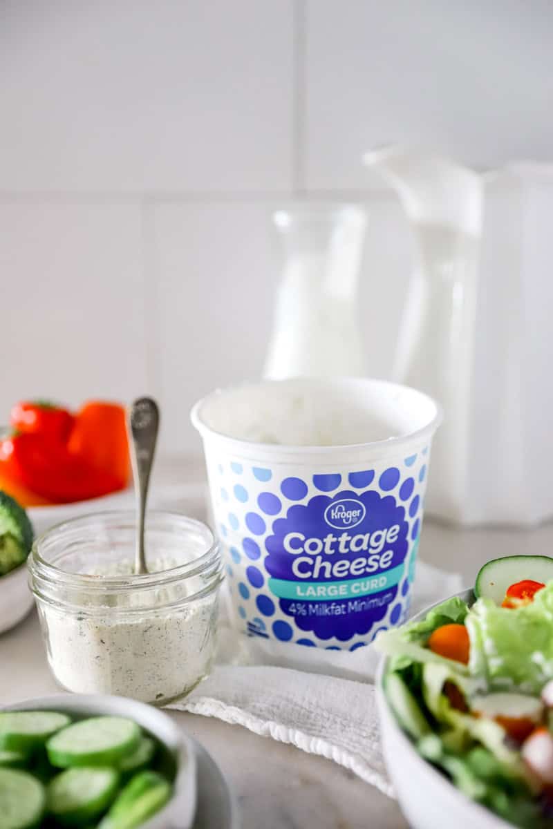 Step 1 of making high protein cottage cheese ranch dip is adding the ranch mix to the cottage cheese.