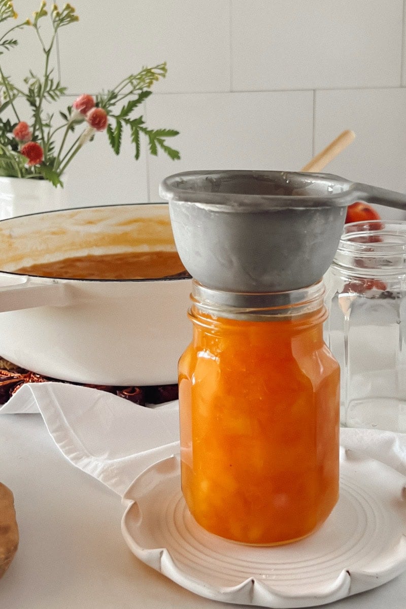 Step 5 Ladle the hot peach preserves into hot jars, leaving ½ inch headspace. Remove any air bubbles.