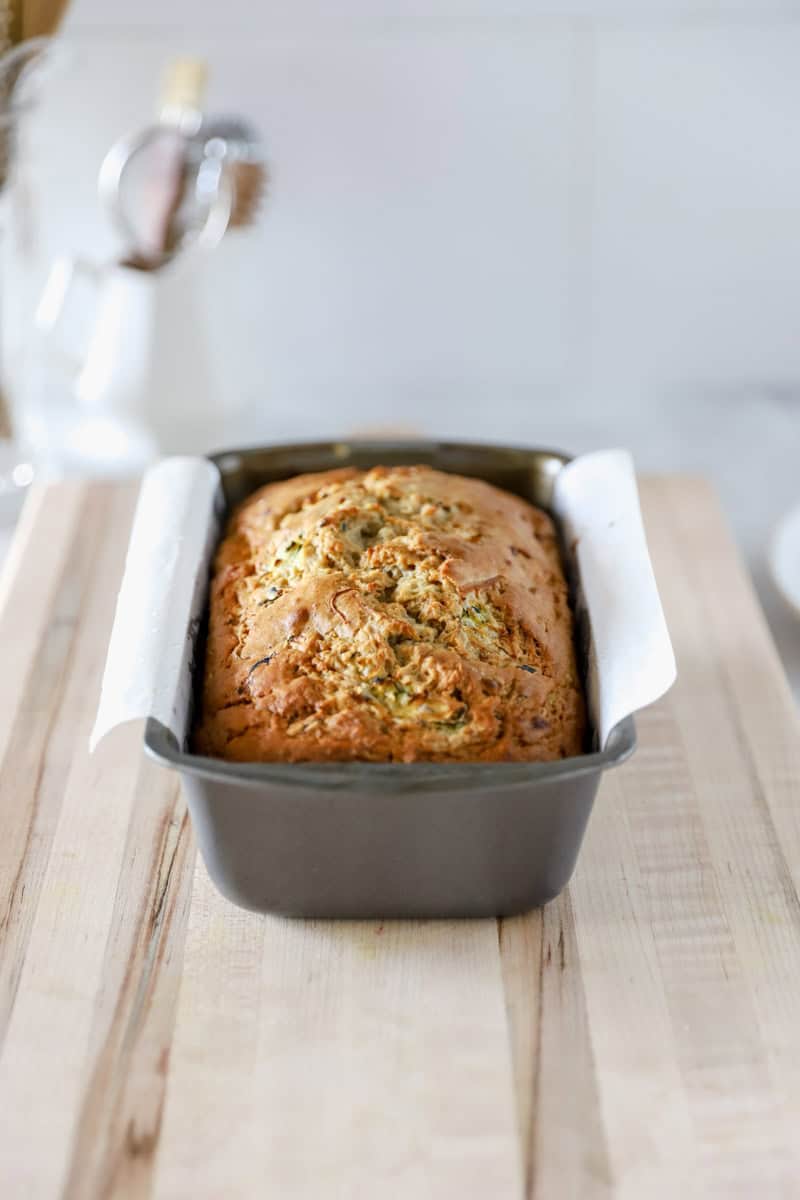 A close up view of a fully baked zucchini banana bread in a bread pan.