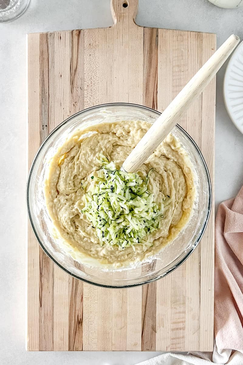 Step 6 of zucchini banana bread is stirring in dry ingredients and zucchini until just combined.