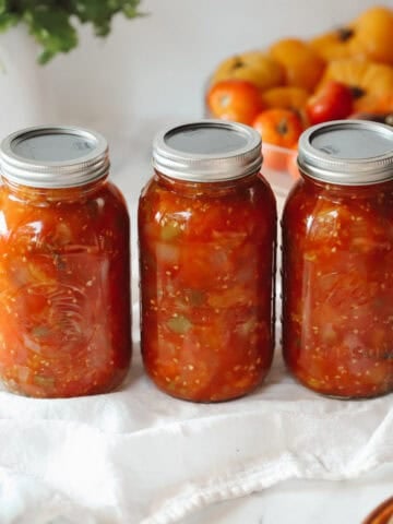 A picture of three jars of chunky homemade salsa for a blog about how to can salsa and how to make homemade salsa.