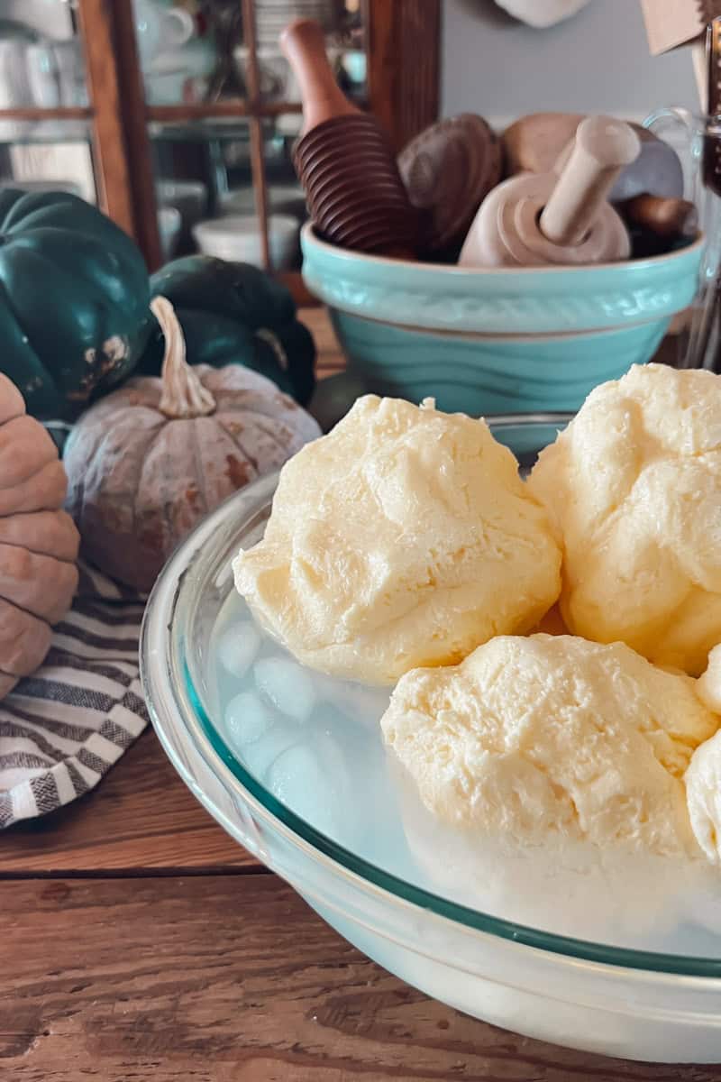 A side view of butter in a bowl of ice water.