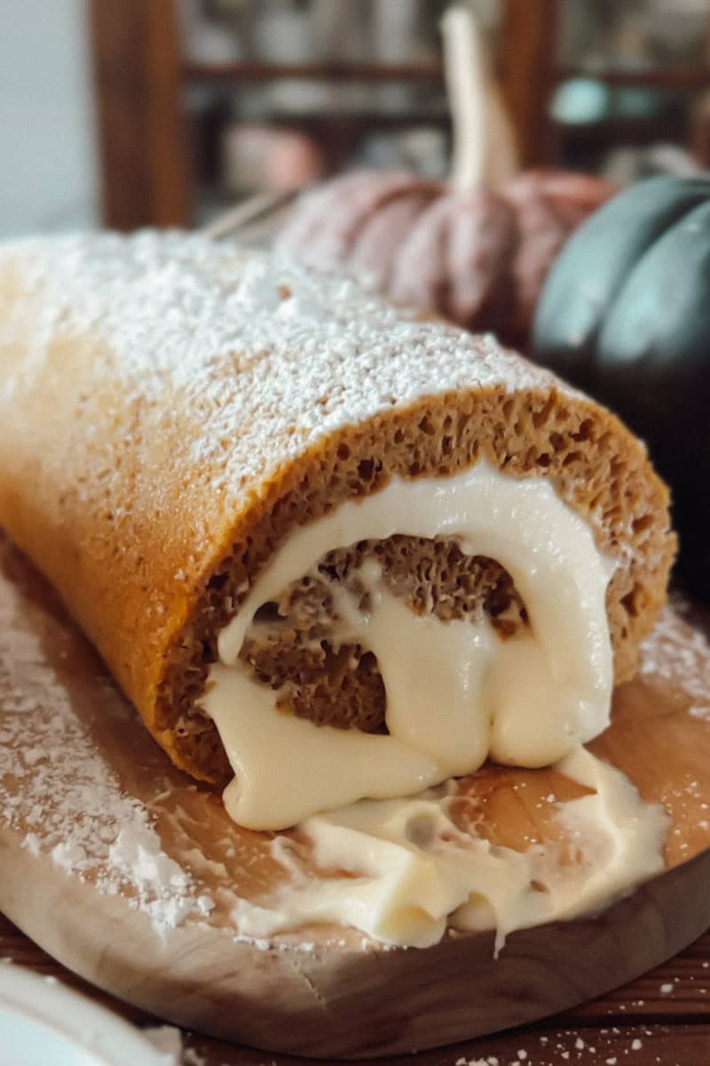 A close up view showing the swirled cream cheese in a sourdough pumpkin roll.