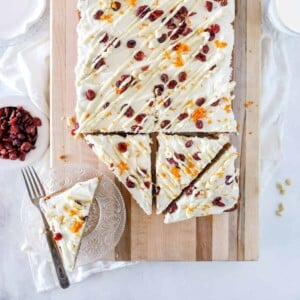 A top view of a batch of sourdough bliss bars with orange zest, dried cranberries and a white chocolate drizzle.