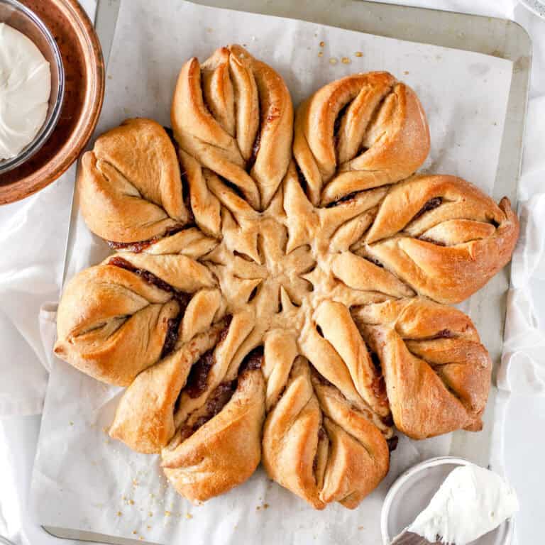 Christmas Star bread on parchment paper and a baking sheet, top view.