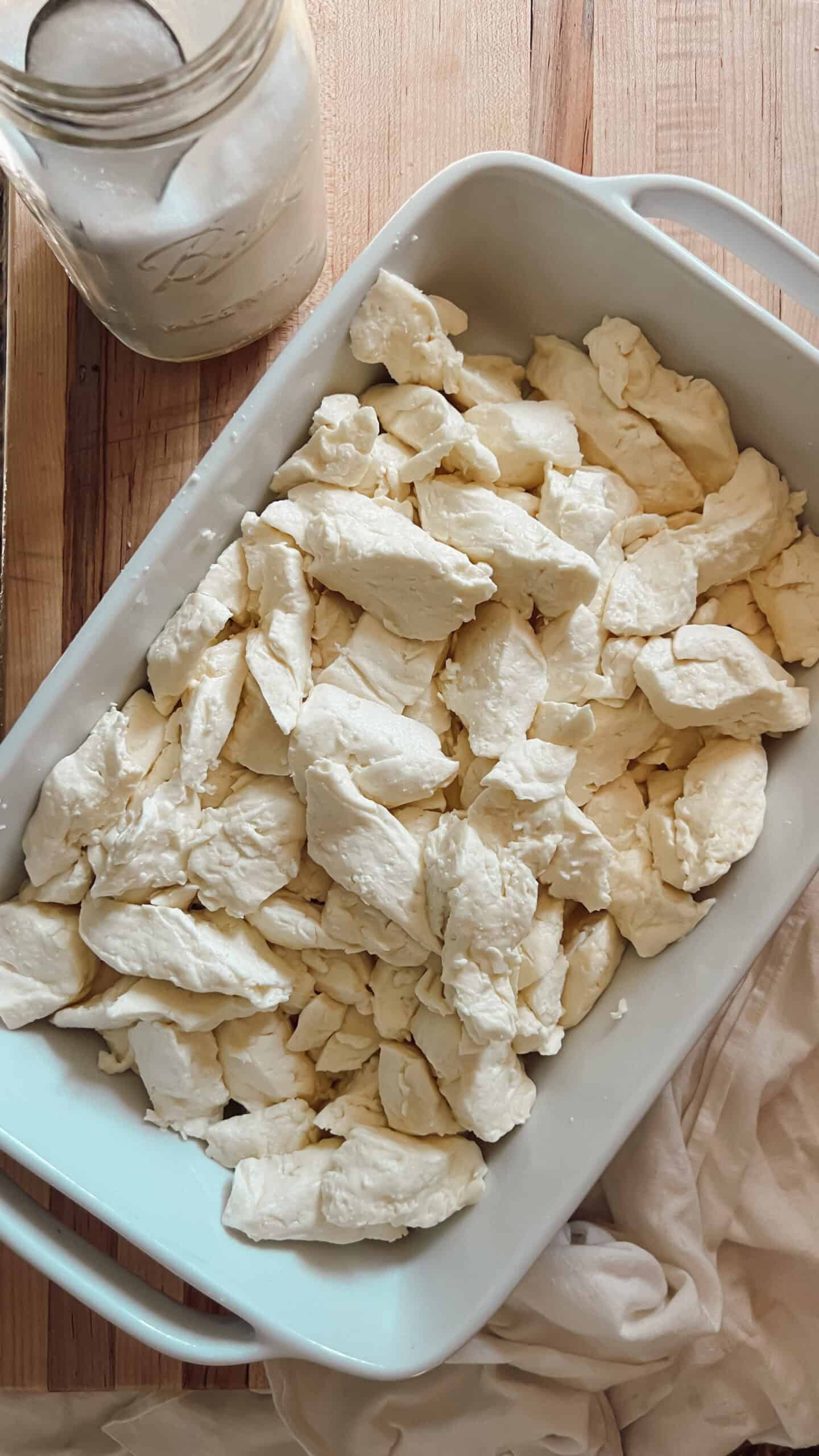 Cheddar cheese curds in a white dish.