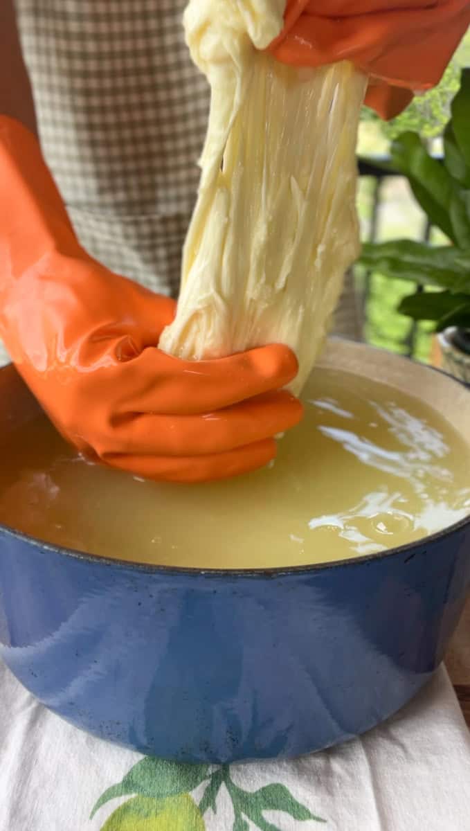Stretching mozzarella cheese in hot whey.