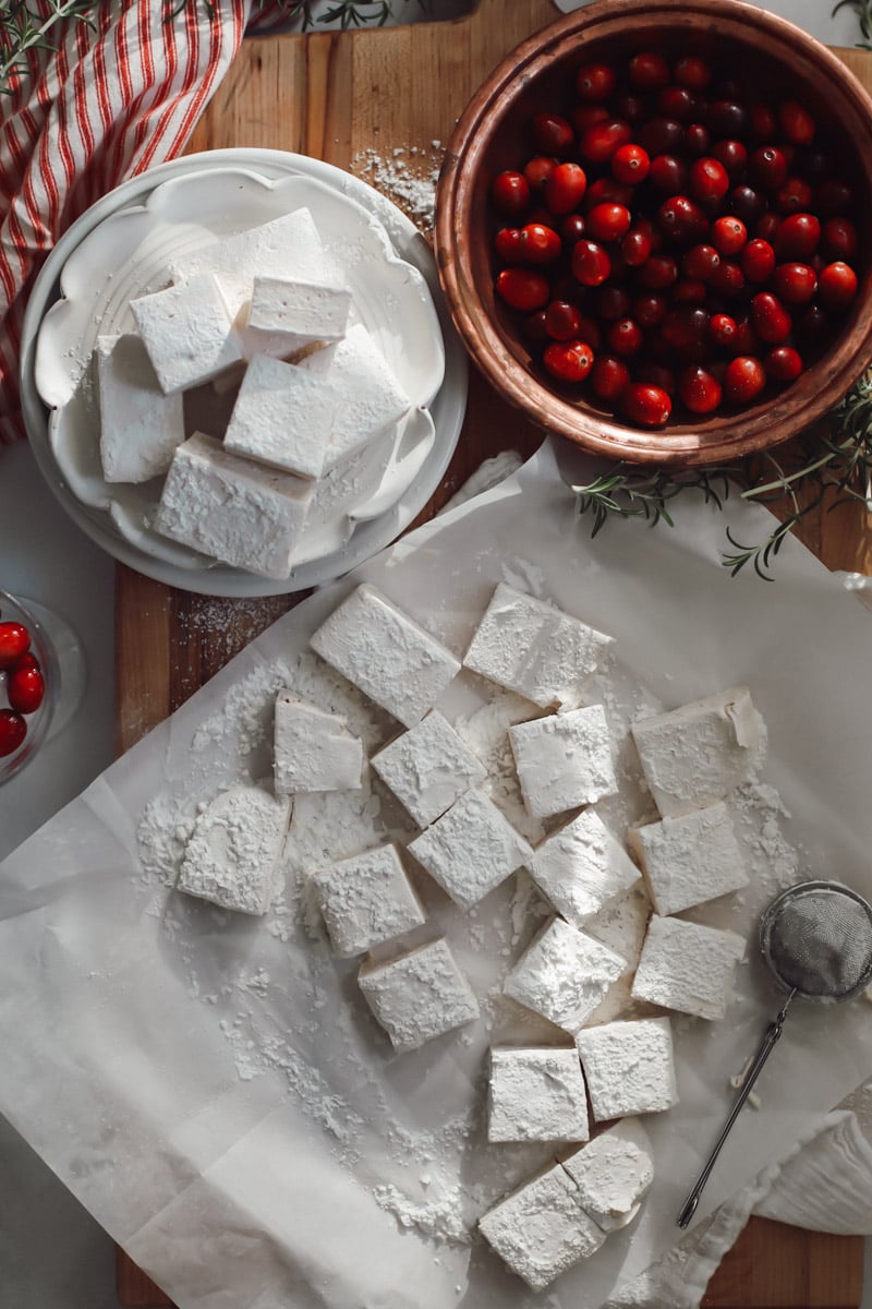 A top view of sliced marshmallows made with cranberry juice on parchment paper.