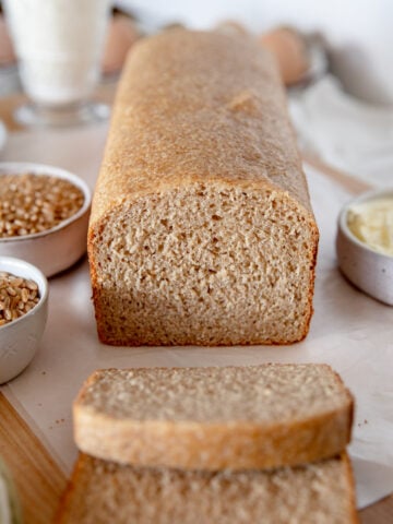 Close-up of sliced whole wheat sourdough sandwich bread showing soft, tight crumb and golden color.