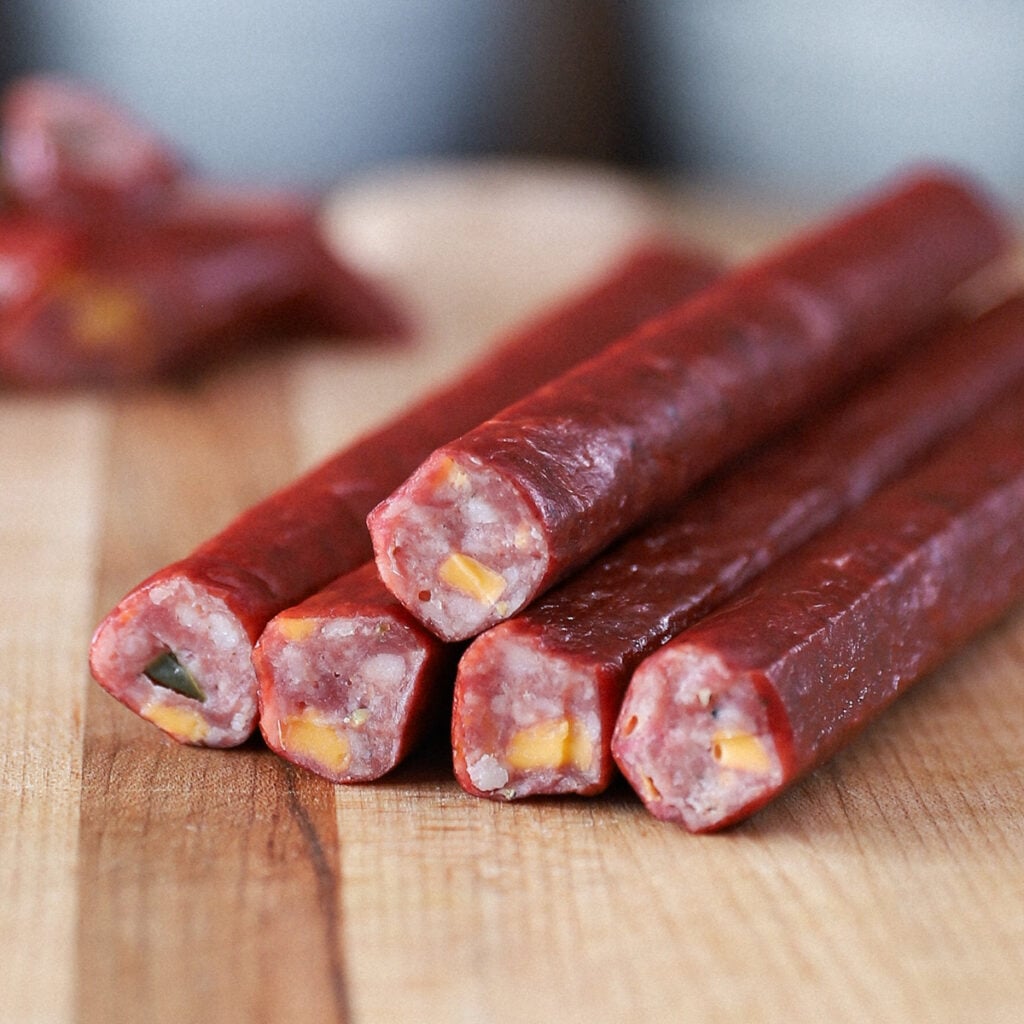 Close-up of sliced jalapeño cheddar snack sticks showing cheese and pepper pieces.