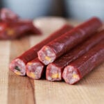 Close-up of sliced jalapeño cheddar snack sticks showing cheese and pepper pieces.