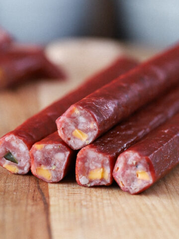 Close-up of sliced jalapeño cheddar snack sticks showing cheese and pepper pieces.