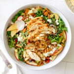 Harvest chicken salad topped with sliced chicken breast, apples, pecans, feta cheese, avocado, and radishes over mixed greens.
