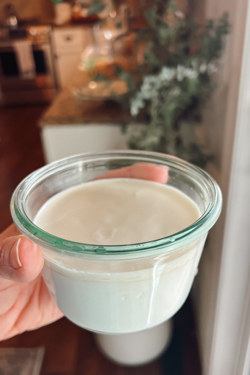 Clabber in a jar, slightly tipped showing how the clabber doesn't slosh but rather moves like pudding.