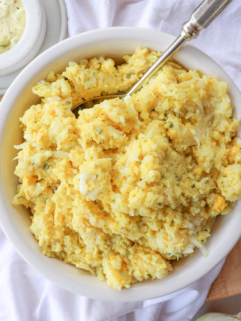 Square overhead photo of old-fashioned German potato salad made with shredded potatoes, eggs, and creamy mustard dressing.