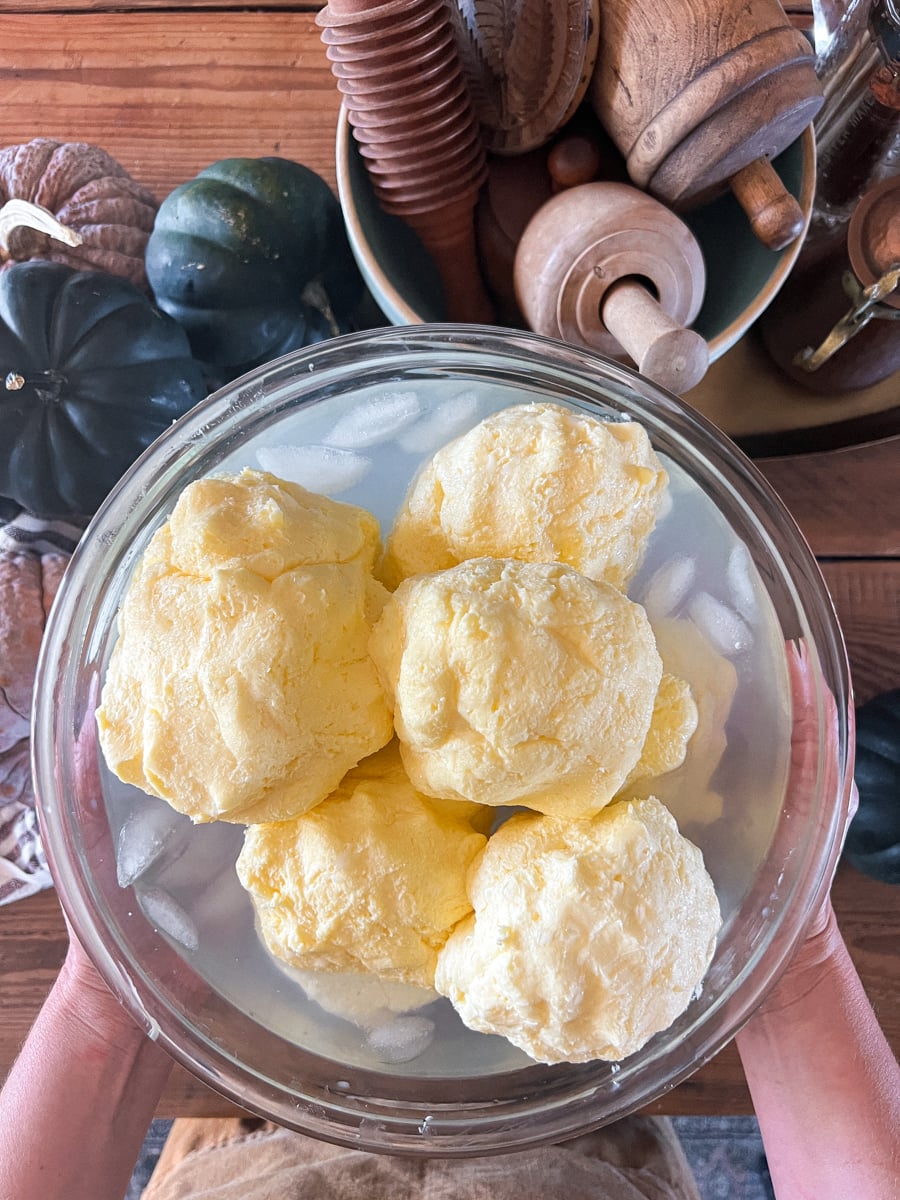 Butter shaped into balls in a bowl of ice water to get firm enough for pressing in an antique butter mold.