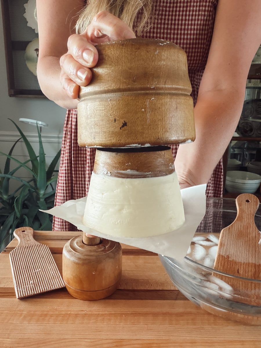 Showing how a butter mold presses butter with the bell holding the shape and the stamp pressing a design.